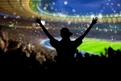 Mand der jubler på et fyldt fodboldstadion